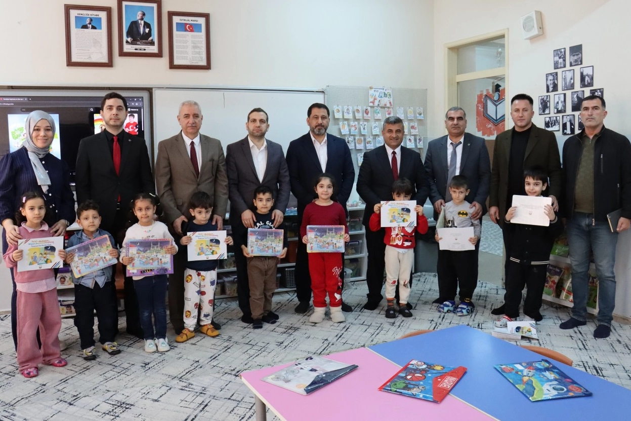 Şanlıurfa Büyükşehir Belediyesi'nin Kütüphaneler Haftası kapsamında Molla Gürani Ortaokulu öğrencilerine kitap hediye ettiği anı gösteren görsel.