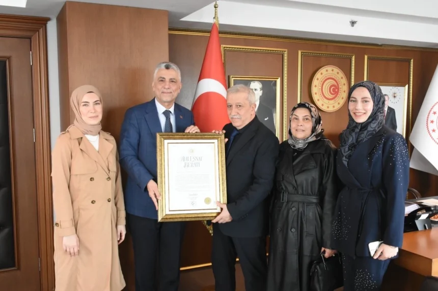 Ticaret Bakanı Ömer Bolat, ücret almayan esnaf Cemalettin Yılmaz'a Ahi Esnaf Beratı takdim ediyor.