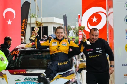 Engelli kadın ralli pilotu Kübra Denizci Keskin Marmaris Ege Rallisi'nde kazandığı kupalarla zafer pozu veriyor.