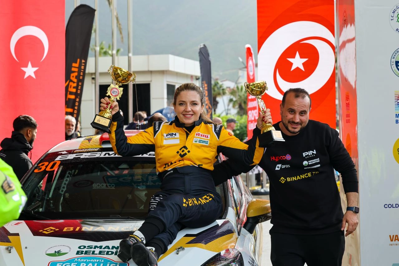 Engelli kadın ralli pilotu Kübra Denizci Keskin Marmaris Ege Rallisi'nde kazandığı kupalarla zafer pozu veriyor.