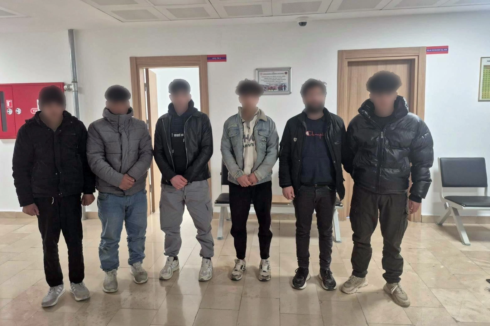 Artvin'de insan kaçakçılığı operasyonu kapsamında yakalanan düzensiz göçmenler ve gözaltına alınan şüpheliler.