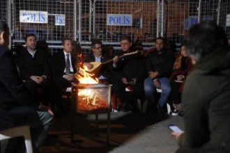 İzmir Meslek Fabrikası'na el konulmasına karşı direnişin üçüncü gününde nöbet tutan vatandaşlar ve belediye başkanı.