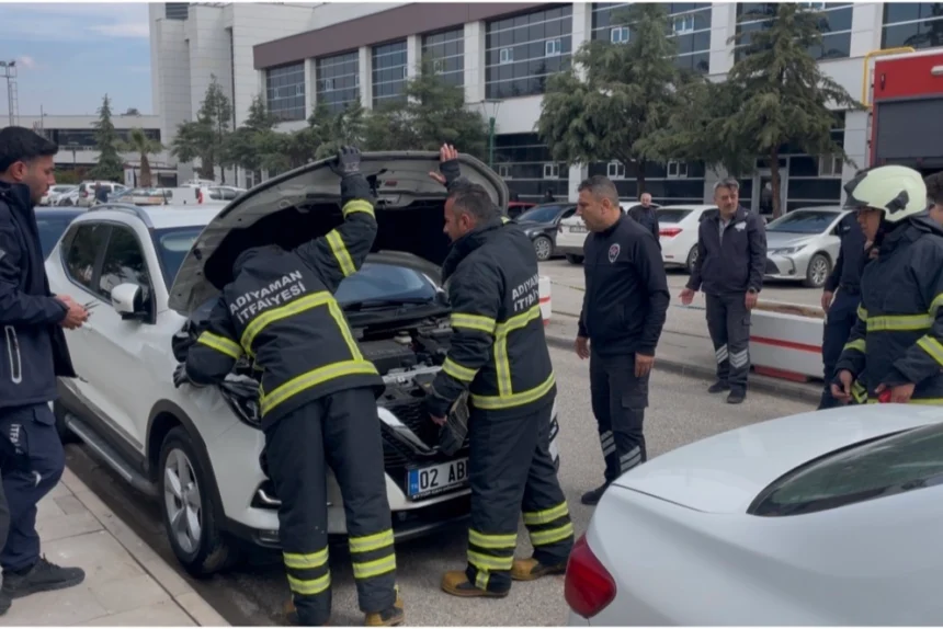 Adıyaman Eğitim ve Araştırma Hastanesi otoparkında park halindeki bir otomobilin motor kısmından dumanlar yükseliyor.