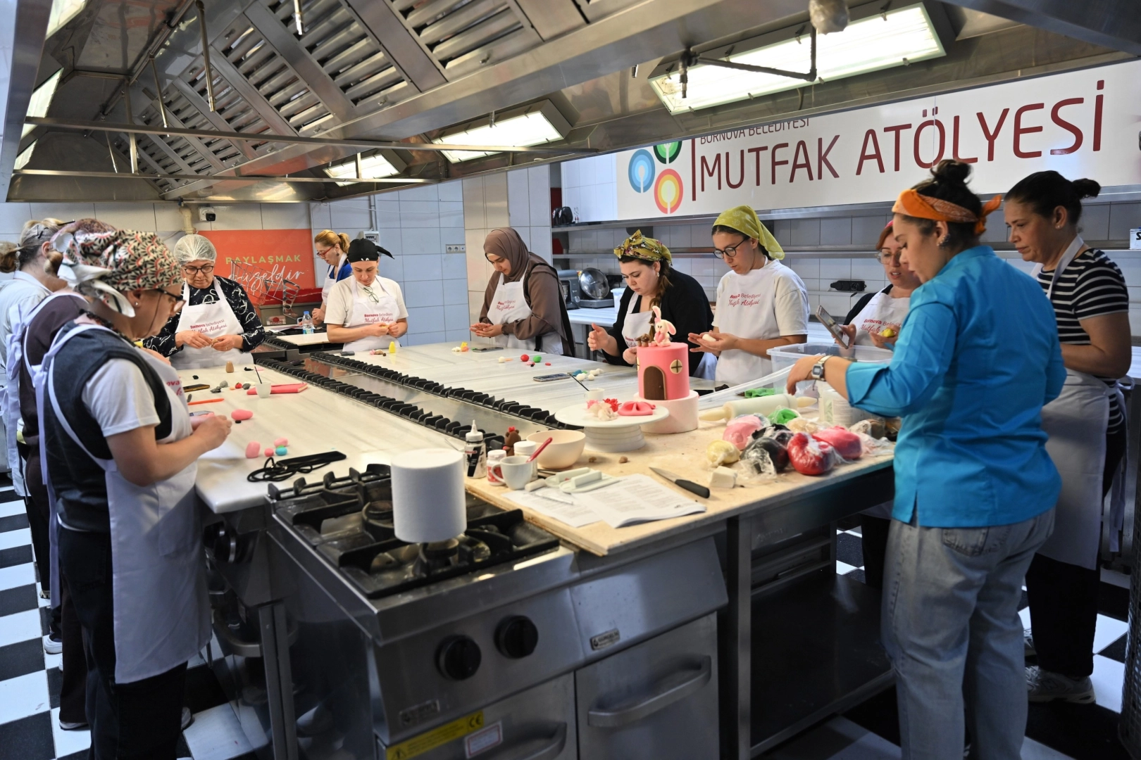 Bornova Belediyesi'nin düzenlediği mutfak atölyelerinden bir kesit, katılımcıların pasta ve makarna yapımına odaklandığı anı gösteriyor.