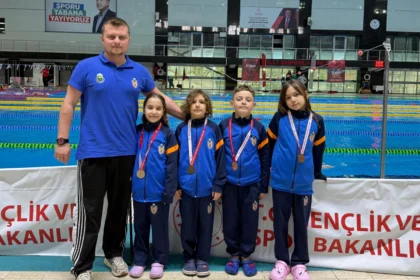 İnegöl Belediyespor yüzme takımı sporcuları madalyalarıyla birlikte