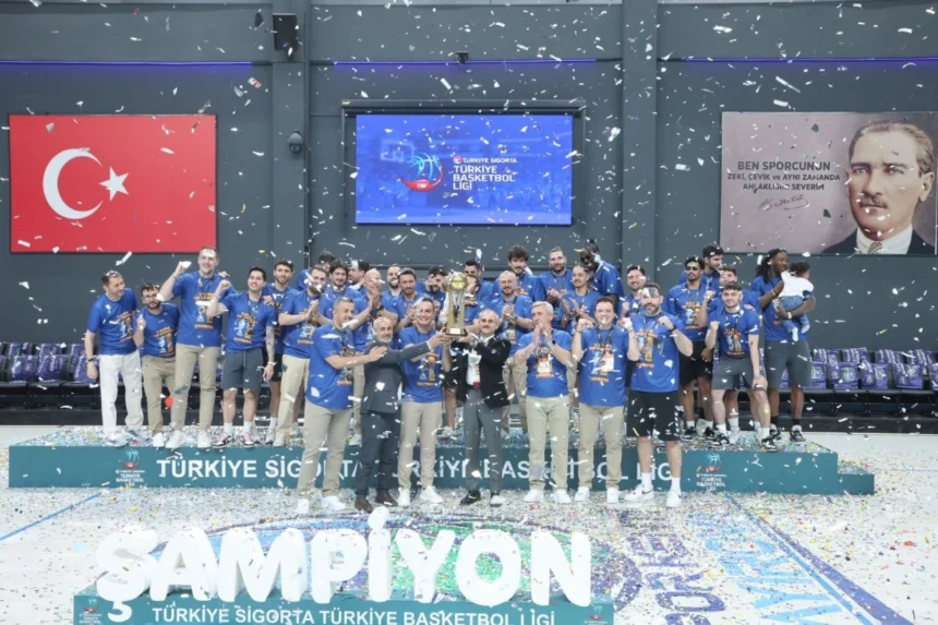 Çayırova Belediyesi Basketbol Takımı oyuncuları ve teknik heyeti şampiyonluk kupasıyla birlikte seviniyor.