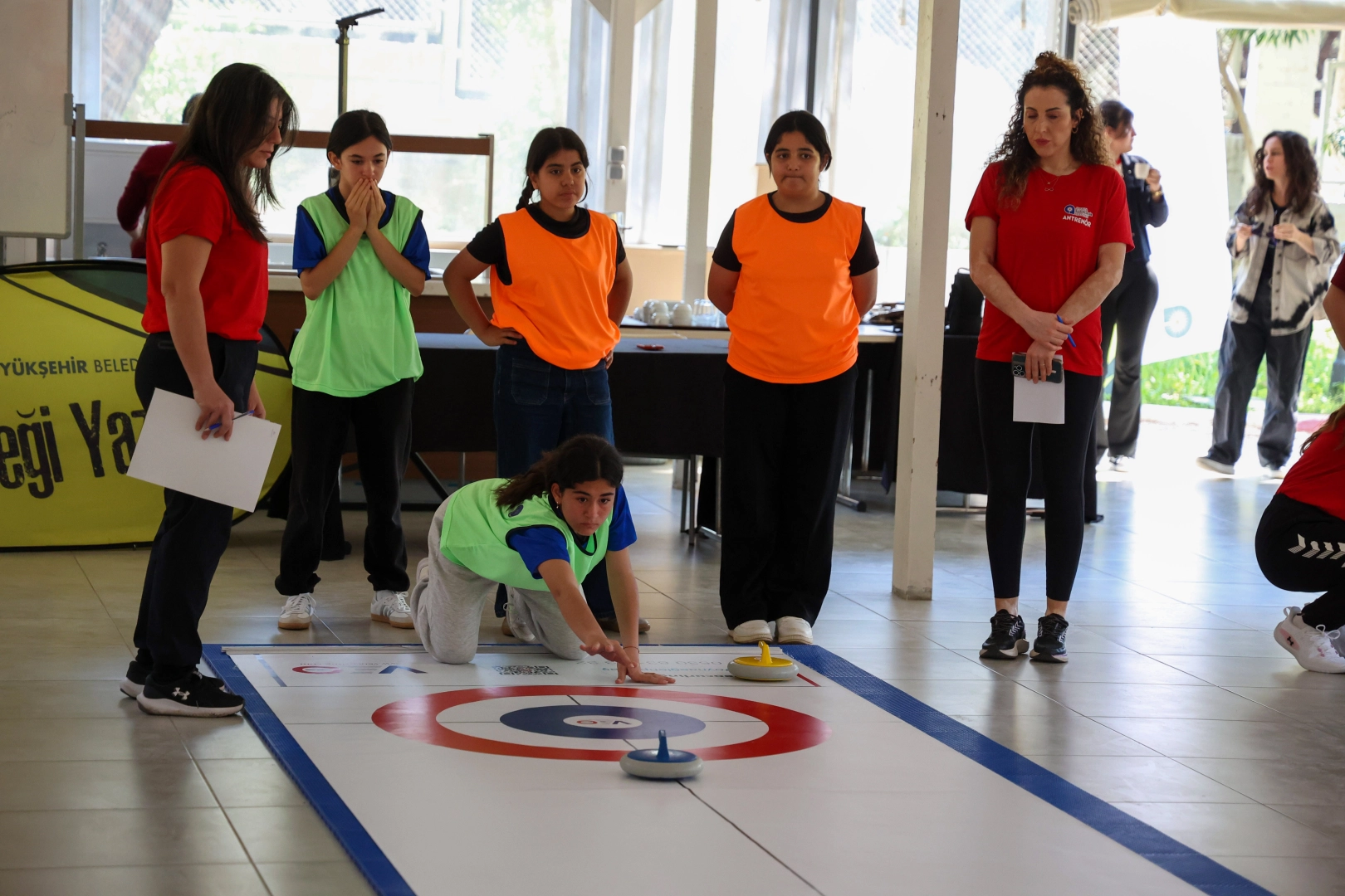 Antalya'da düzenlenen floor curling turnuvasında mücadele eden kız çocukları ve şampiyon olan Menderes Ortaokulu takımı.