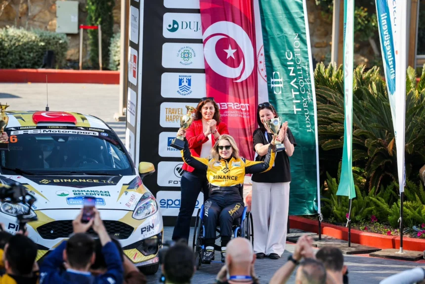 Engelli kadın ralli pilotu Kübra Denizci Keskin, Bodrum Rallisi'nde kazandığı kupalarla objektiflere gülümsüyor.